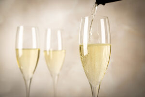 Festive photo of pouring sparkling wine into glasses